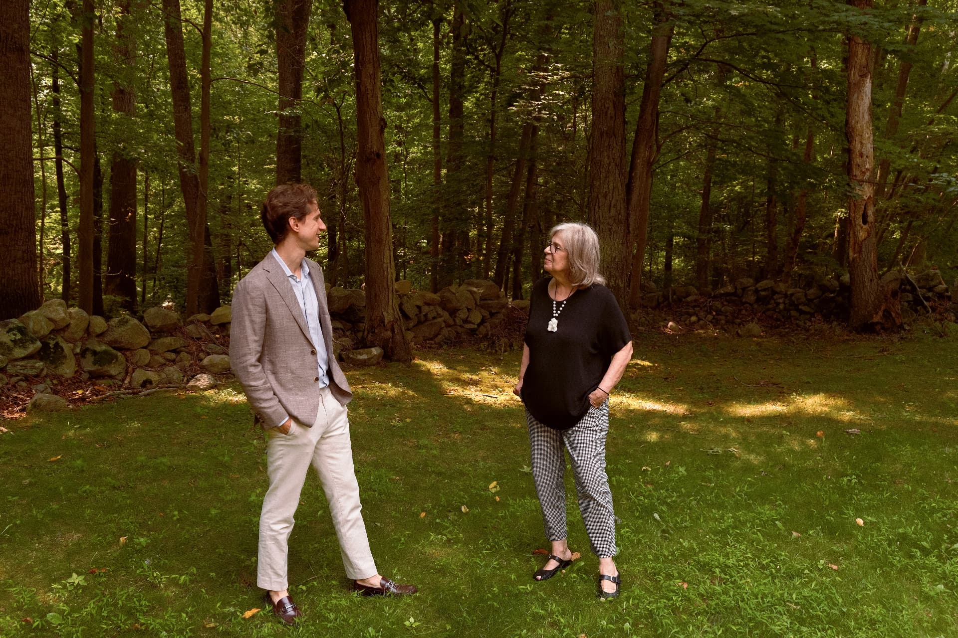 Two members of the Sycamore Collection leadership team in conversation on the wooded grounds in North Stamford.